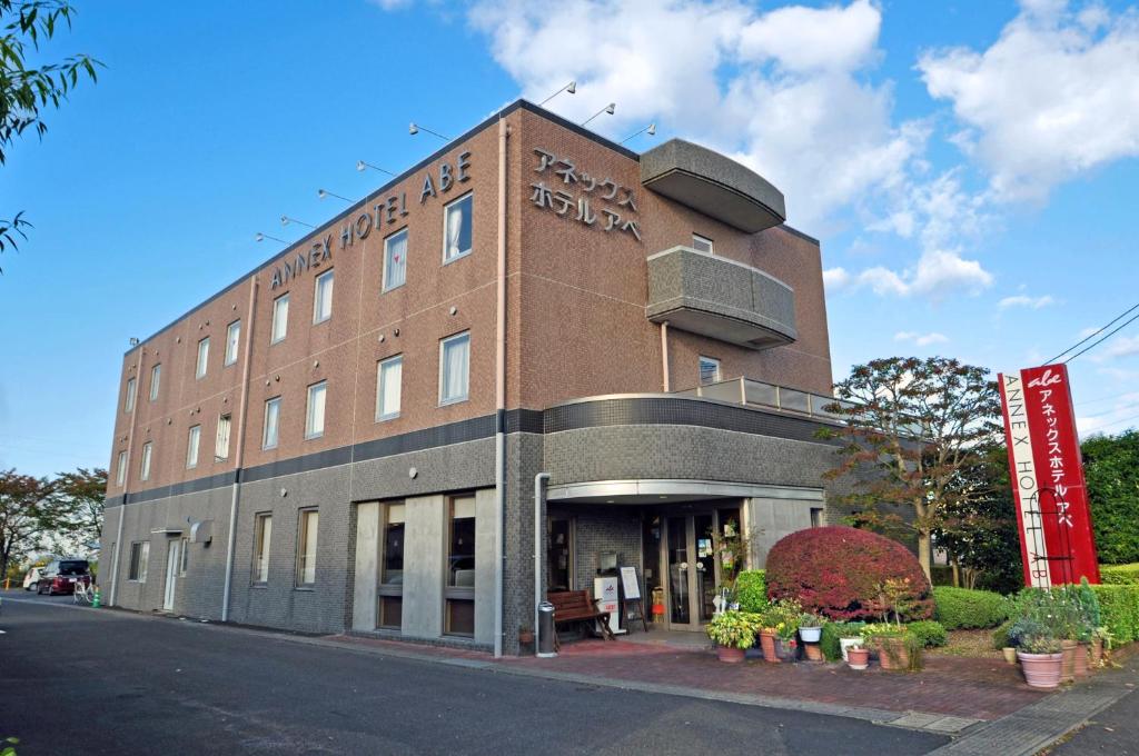 a large brick building on the side of a street at Annex Hotel Abe in Kurihara