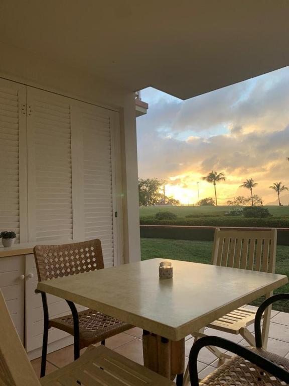 a table and chairs on a porch with a view of the sunset at Pierre et Vacances Vue Mer in Sainte-Luce