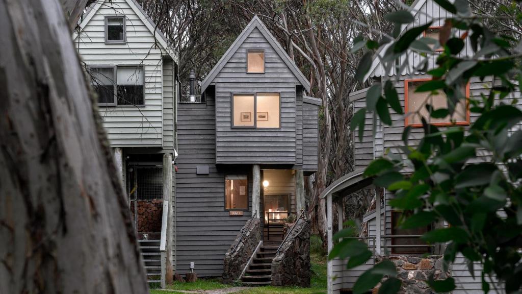 a gray house with stairs leading up to it at Blairs in Dinner Plain