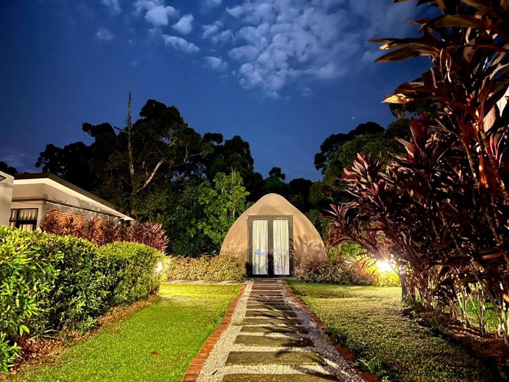 une maison avec une porte dans un jardin la nuit dans l'établissement PLAY at Lot 31 Eco Orchard Melaka, 