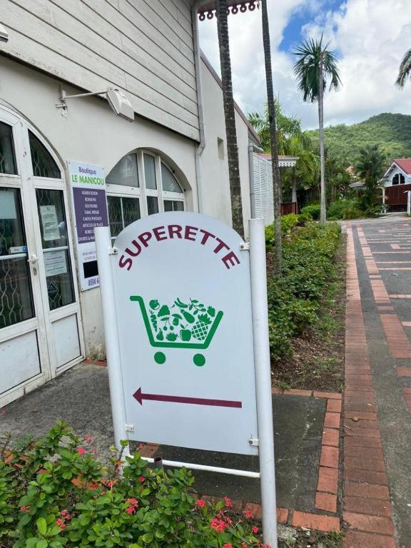 a sign in front of a store with a shopping cart at Pierre et Vacances Vue Mer in Sainte-Luce