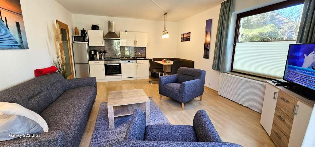 a living room with a couch and chairs and a tv at Wohnung-C-305 in Böhl
