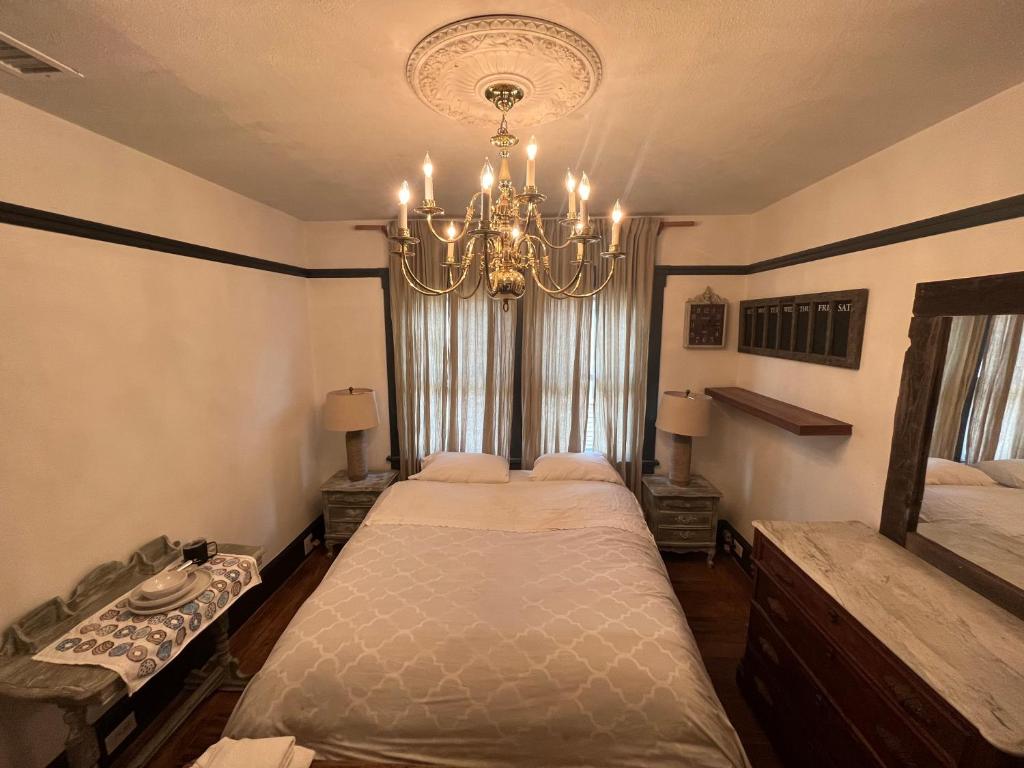 a bedroom with a large bed with a chandelier at Elle’s house in San Rafael