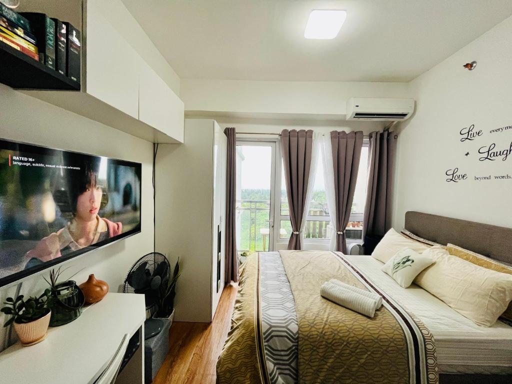 - une chambre avec un lit et une télévision à écran plat dans l'établissement Lovely studio unit with fast Wi-Fi and Netflix, à Tagaytay