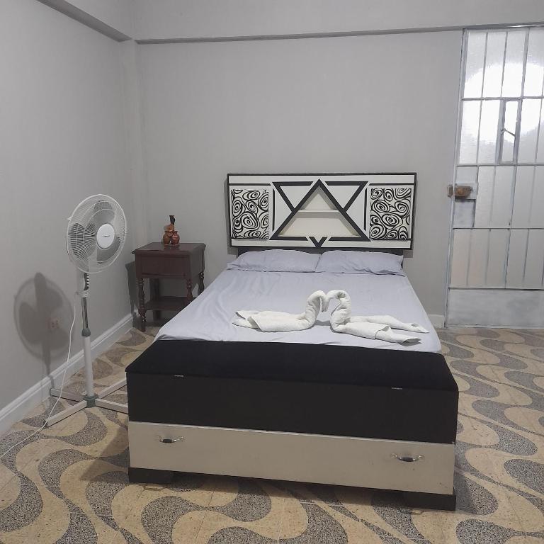 um quarto com uma cama com duas toalhas brancas em Travel house ica em Ica
