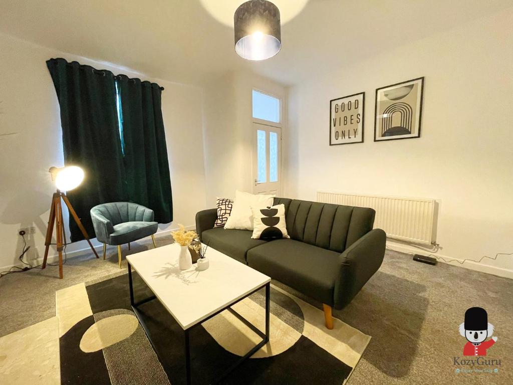 ウィガンにあるKozyGuru / Wigan / 2BR 4Beds / Newly Refurbished Stylish Holiday House / Close to Big Retail Park / UWNE034のソファとテーブルのあるリビングルーム