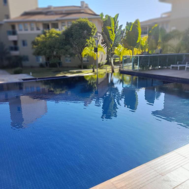 una piscina con acqua blu di fronte a un edificio di Flat - VISTA PARA PISCINA a Brasilia