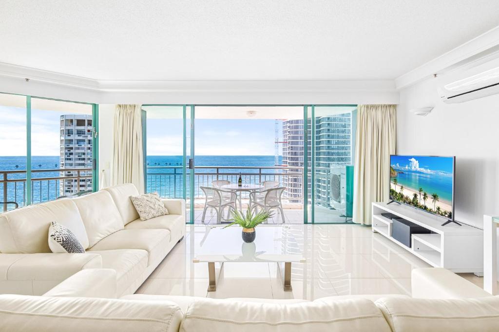ein Wohnzimmer mit einem weißen Sofa und einem TV in der Unterkunft Crown Towers Resort - Private 3 Bedroom Apartment in Gold Coast