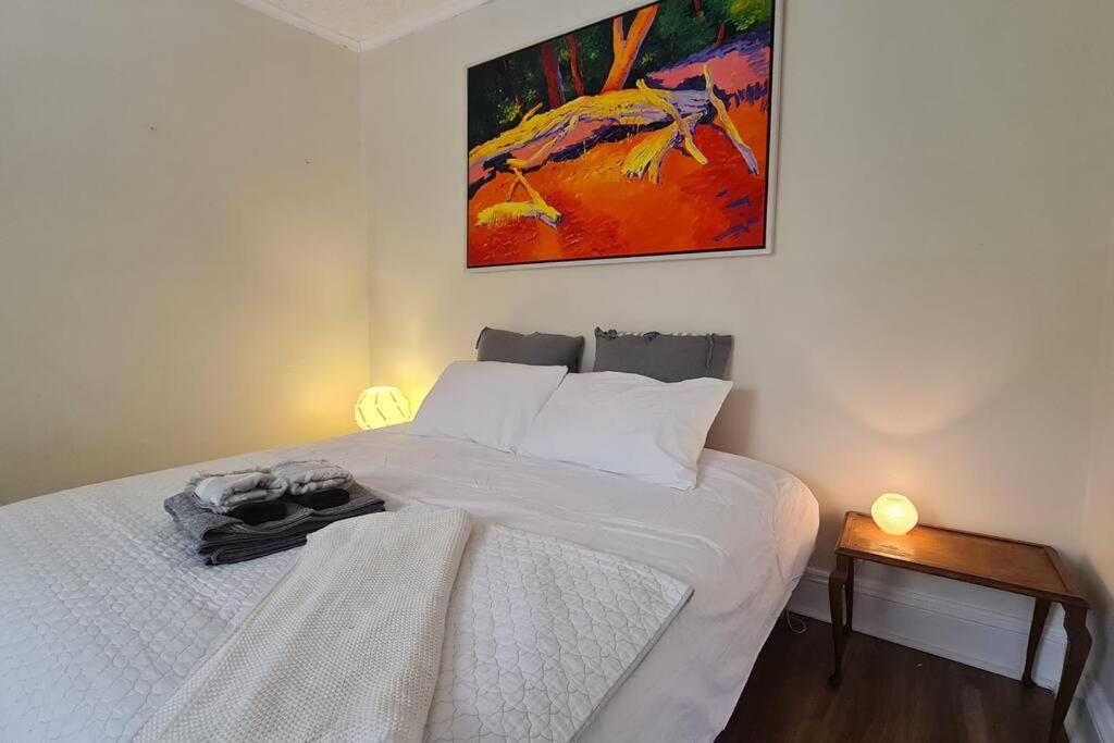 a bedroom with a bed and a painting on the wall at The Secret Figtree Cottage in Clare