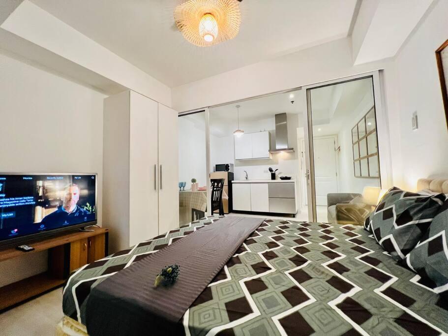 1 dormitorio con 1 cama grande y TV de pantalla plana en Azure Balay, en Manila