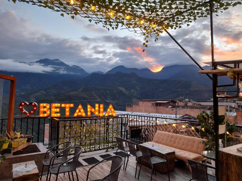 un balcón con mesa, sillas y un cartel en Hotel & Rooftop Farallones, en Betania