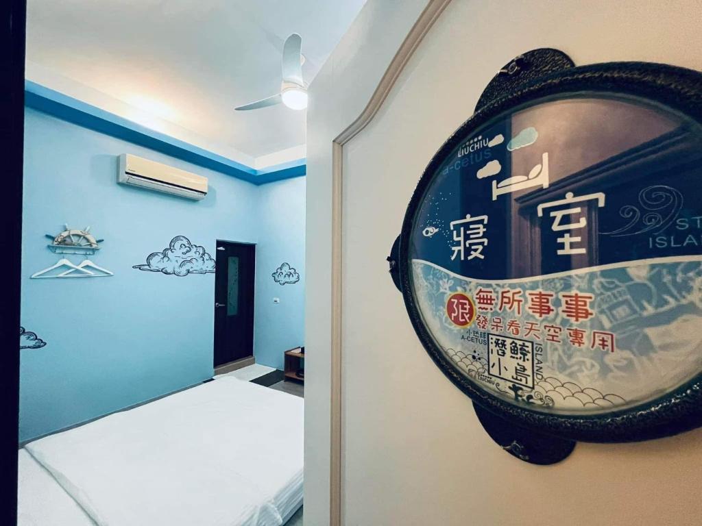 a room with a clock hanging on the wall at Divewhale Homestay in Xiaoliuqiu