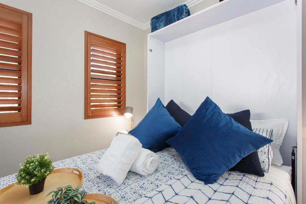 a bedroom with a bed with blue pillows at Bambino 438 in Perth