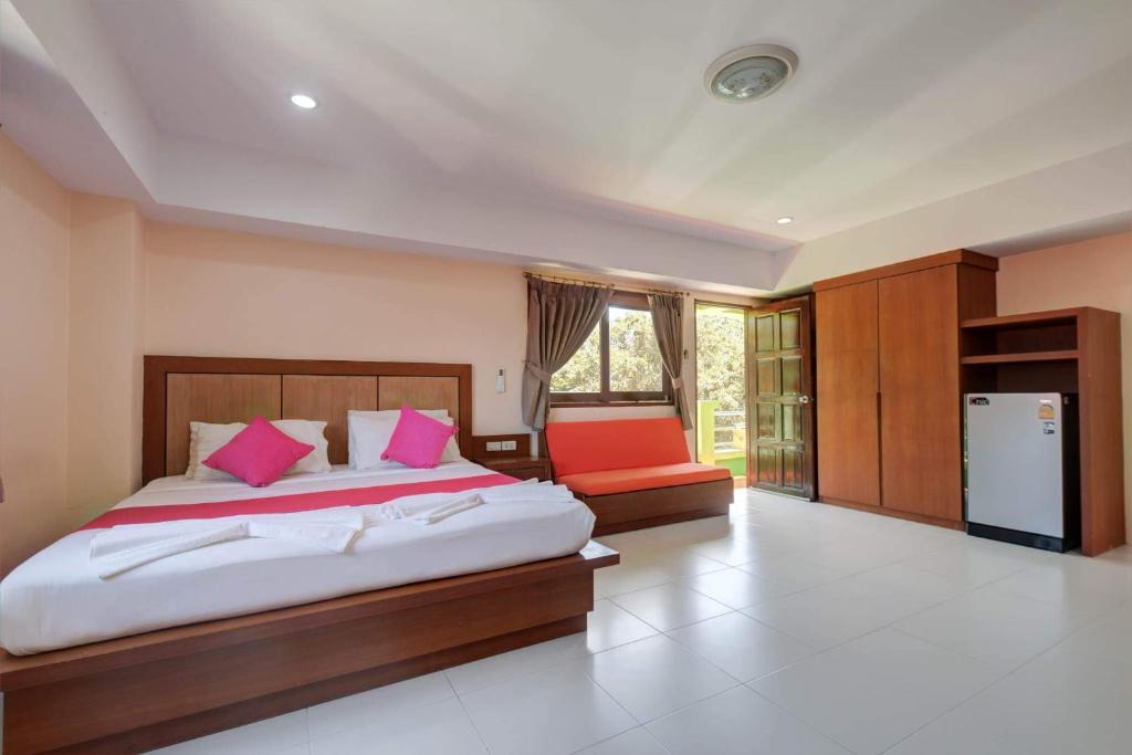 a bedroom with a large bed with pink pillows at Rak Samui Residence in Bophut