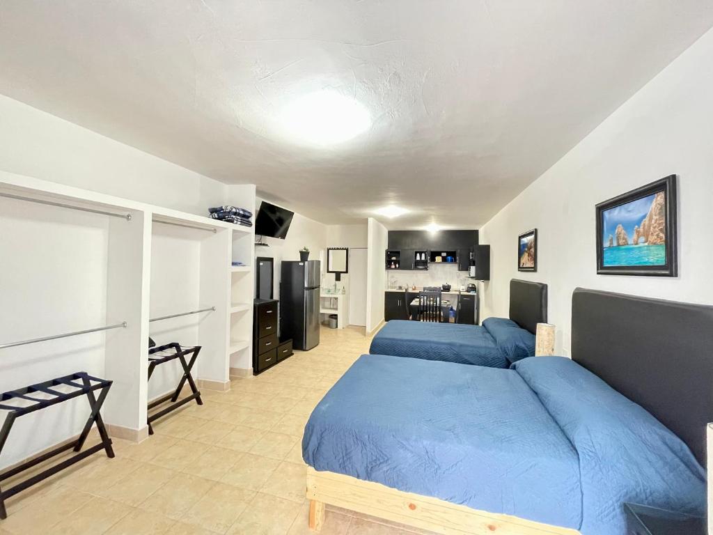 1 Schlafzimmer mit 2 blauen Betten und einer Küche in der Unterkunft Departamento Loft Ejecutivo Privado Confortable Minisplit Amenidades in Torreón