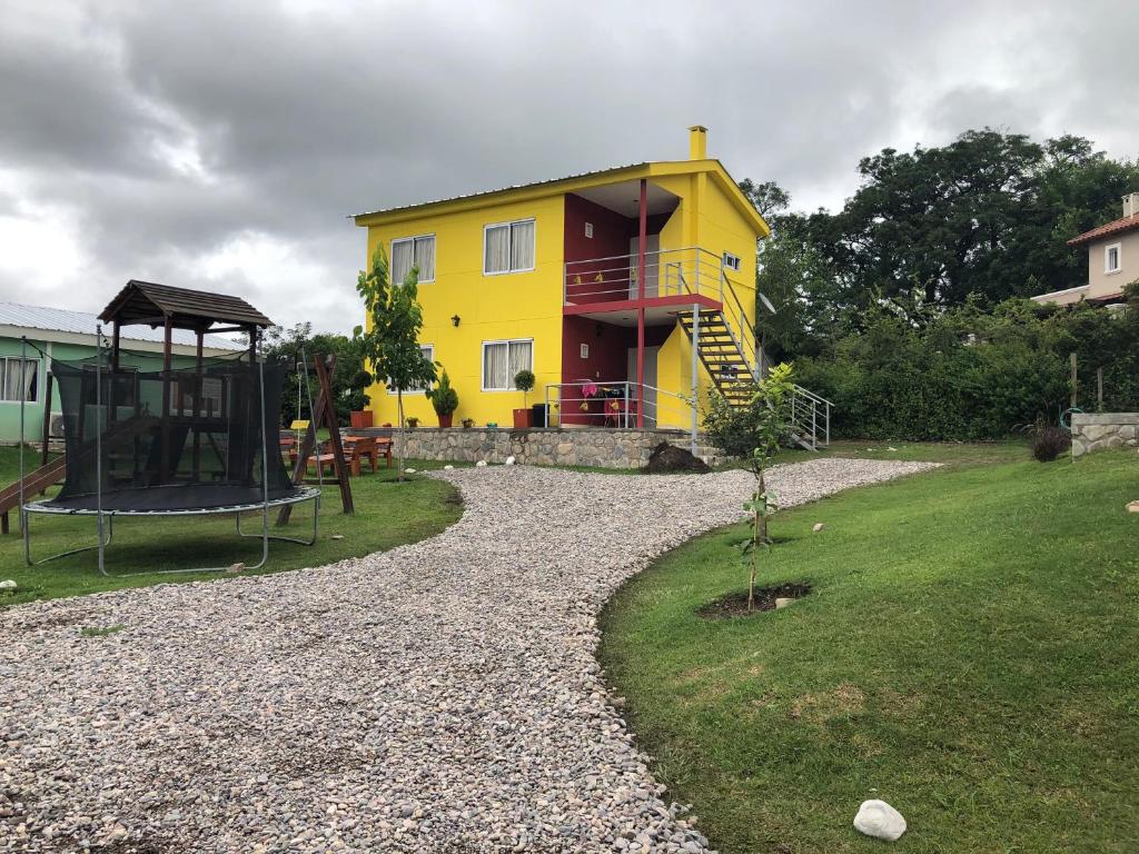 a yellow house with a playground in front of it at WaraKusi Country Houses - Ground floor - Off Road in Vaqueros