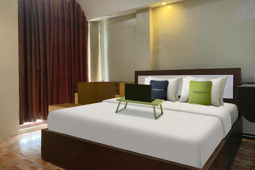een slaapkamer met een groot bed en een laptop. bij Urbanview Hotel Sabang Land Syariah Jayapura in Jayapura