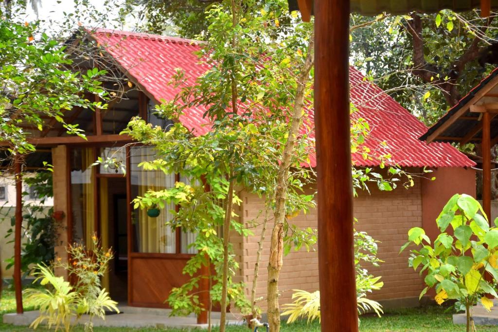 uma pequena casa com um telhado vermelho em Ranathisara Grand Cabanas em Kurunegala