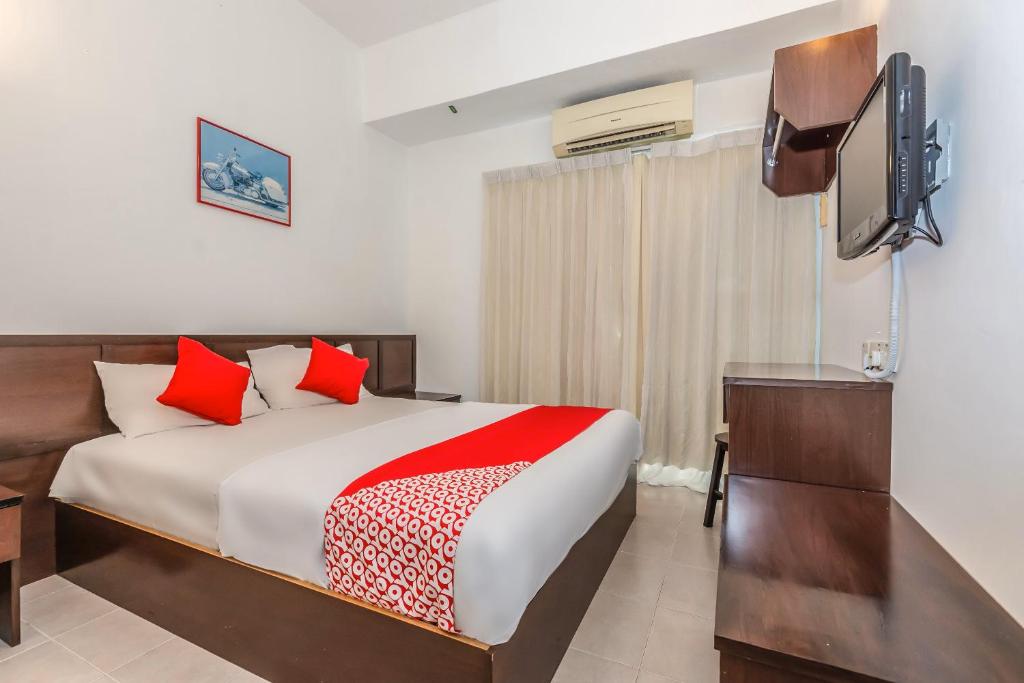 a bedroom with a bed and a flat screen tv at Hash House Hotel in Melaka