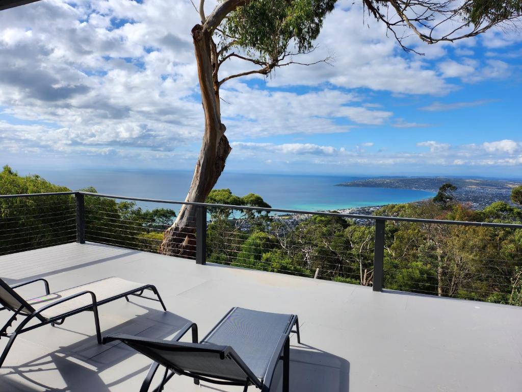 a balcony with chairs and a view of the ocean at Arthurs Holiday Villa in Arthurs Seat