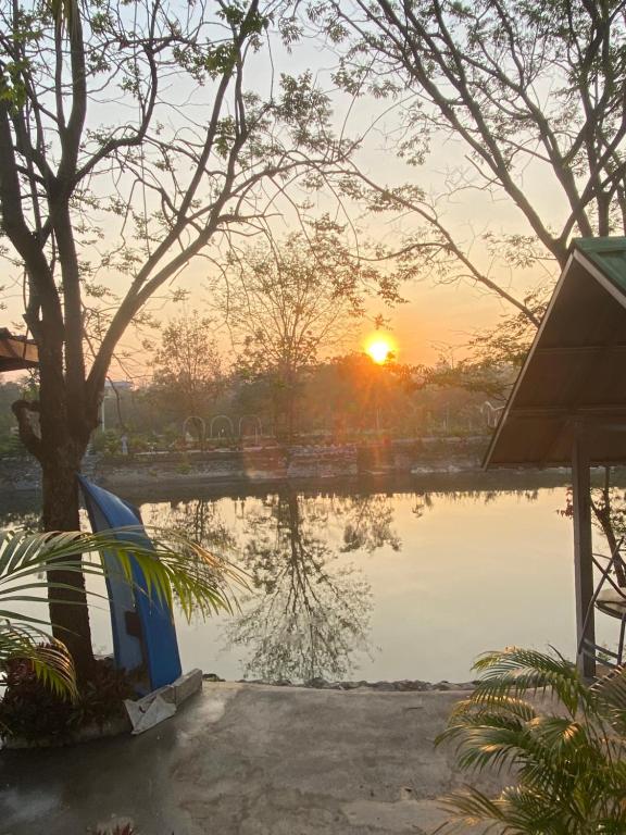 una puesta de sol sobre un estanque con puesta de sol en Ban Lake View en Pak Chong
