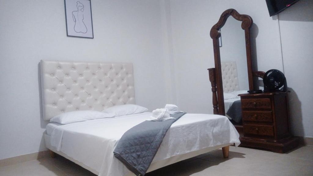 Dormitorio blanco con cama, tocador y espejo en Tu hogar en Cali Apto centrico cómodo y privado en Cali