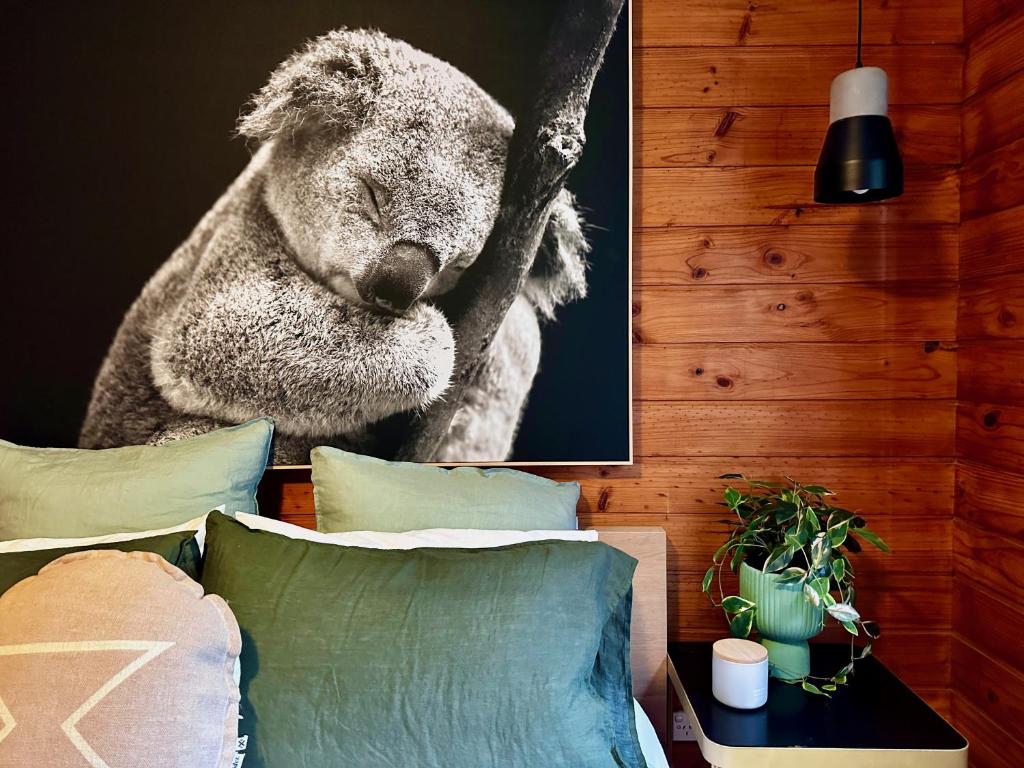a picture of a koala hanging above a bed at Kangaroo Valley Timber Cabin in Kangaroo Valley