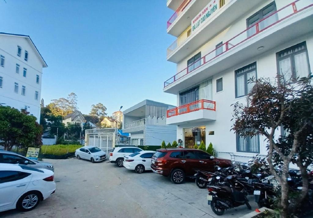 un grupo de autos estacionados en un estacionamiento frente a un edificio en Đà Lạt Cao Nguyên Hotel, en Da Lat