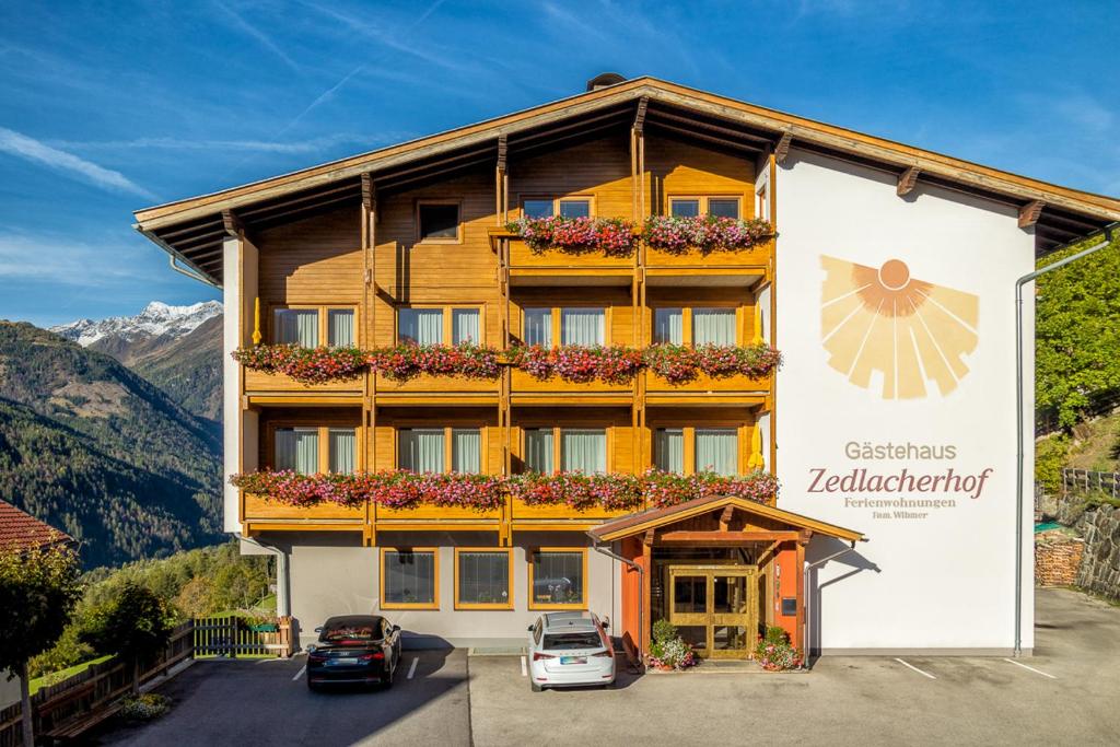 um grande edifício com carros estacionados em frente em Gästehaus Zedlacherhof em Matrei in Osttirol