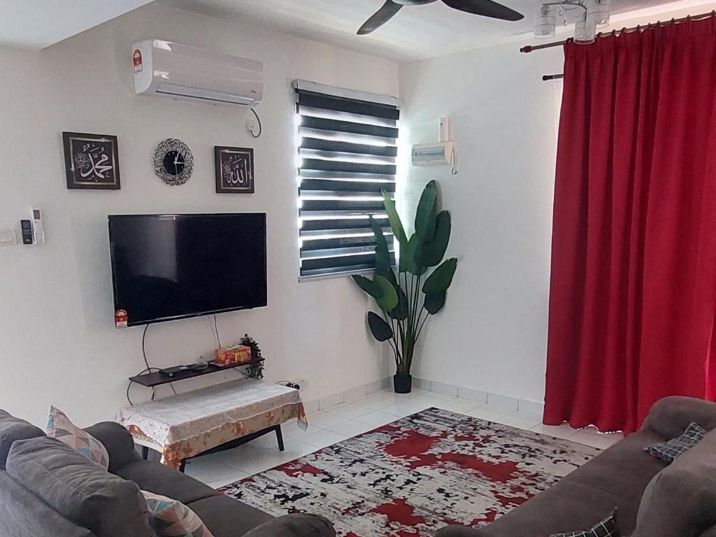 a living room with a tv and a red curtain at Nur Homestay Residensi Afamosa mslim guest only in Kampong Alor Gajah