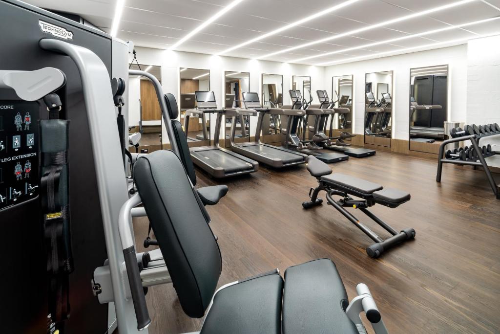 a gym with rows of exercise bikes and treadmills at FIVE Zurich - Luxury City Resort in Zürich