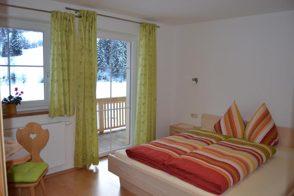 sypialnia z łóżkiem i dużym oknem w obiekcie Apartment Santnerhof w mieście Virgen
