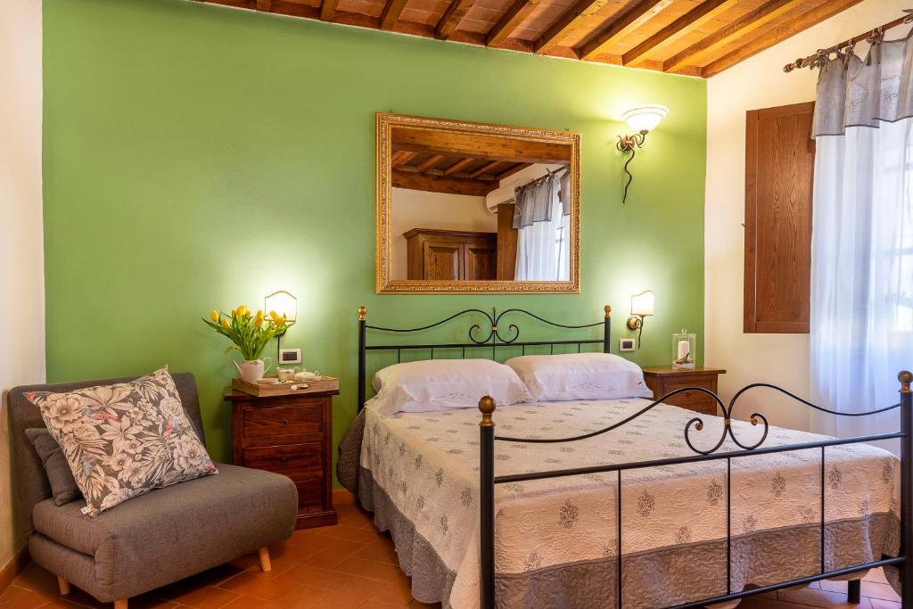 1 dormitorio con cama, espejo y silla en Il Cerreto, en La Pesta