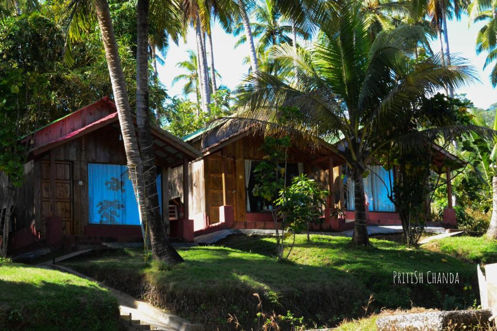 a cottage on the beach with palm trees at GRAND OCEANUS RESORT in Beadonābād