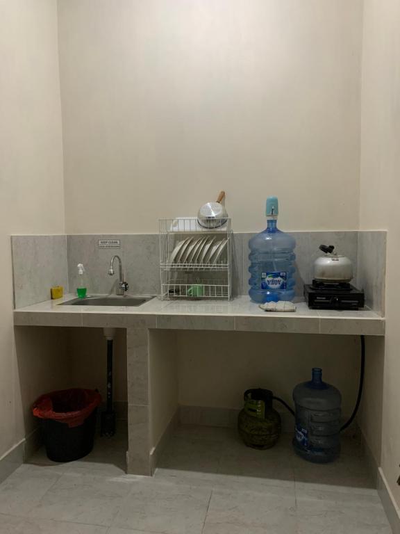 a kitchen counter with a sink and two bottles of water at Besakih Homestay & Villa in Besakih