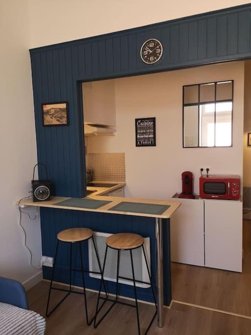 トゥールーズにあるAppartement cosy au centre-ville de Toulouseの小さな家のカウンターに2脚のスツールが備わるキッチン