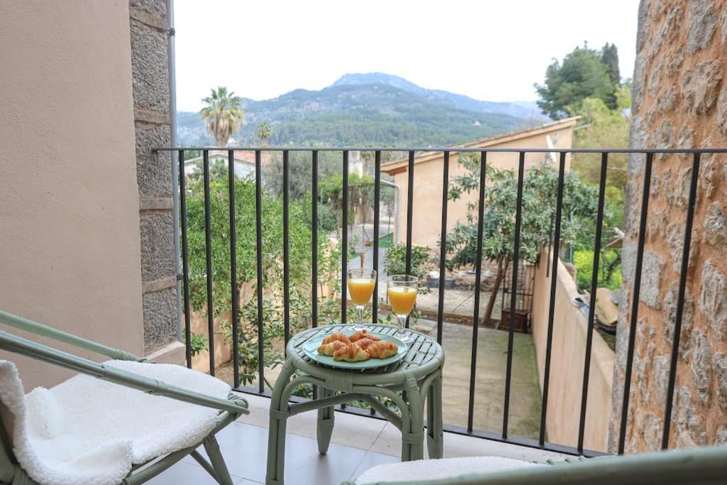 balcón con mesa y 2 vasos de zumo de naranja en Villa Ca'n Pipeta, casa mallorquina centro Soller, en Sóller