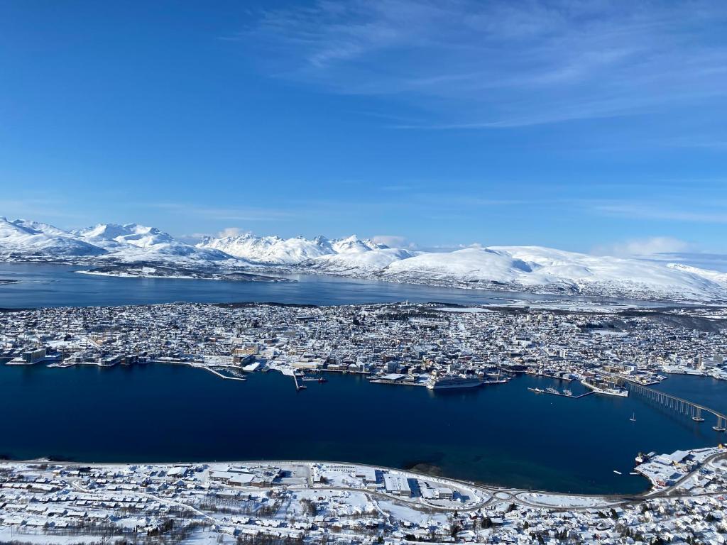 an aerial view of a city with snow covered mountains at Apartment Tromsdalen. Tromsø in Tromsø