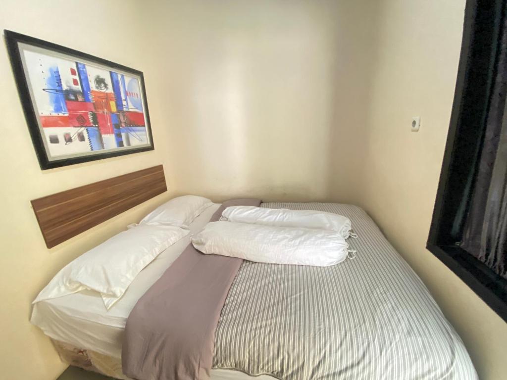 De Homestay Mitra RedDoorz Bitung tesisinde bir odada yatak veya yataklar