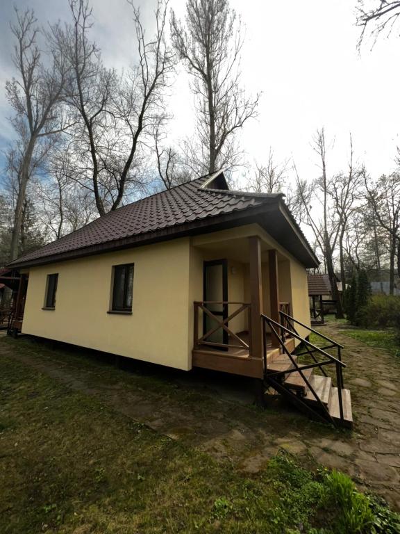 uma pequena casa branca com um telhado preto em Baza Pădurice em Vadul lui Voda