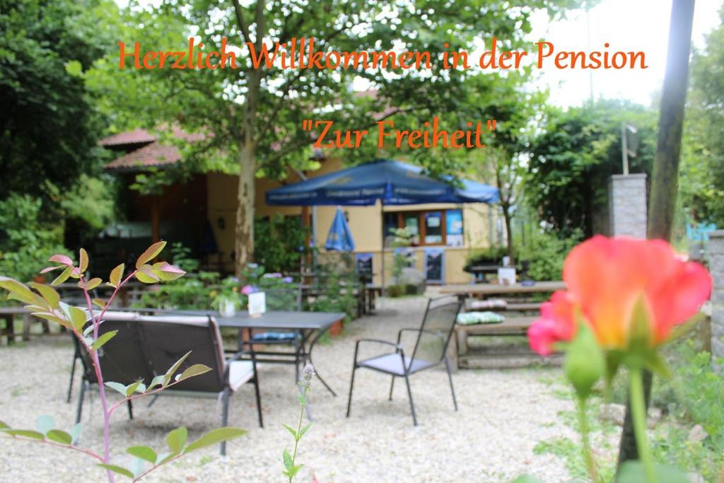 una mesa de picnic y sillas en un jardín con mesa y sillas en Pension Zur Freiheit, en Passau