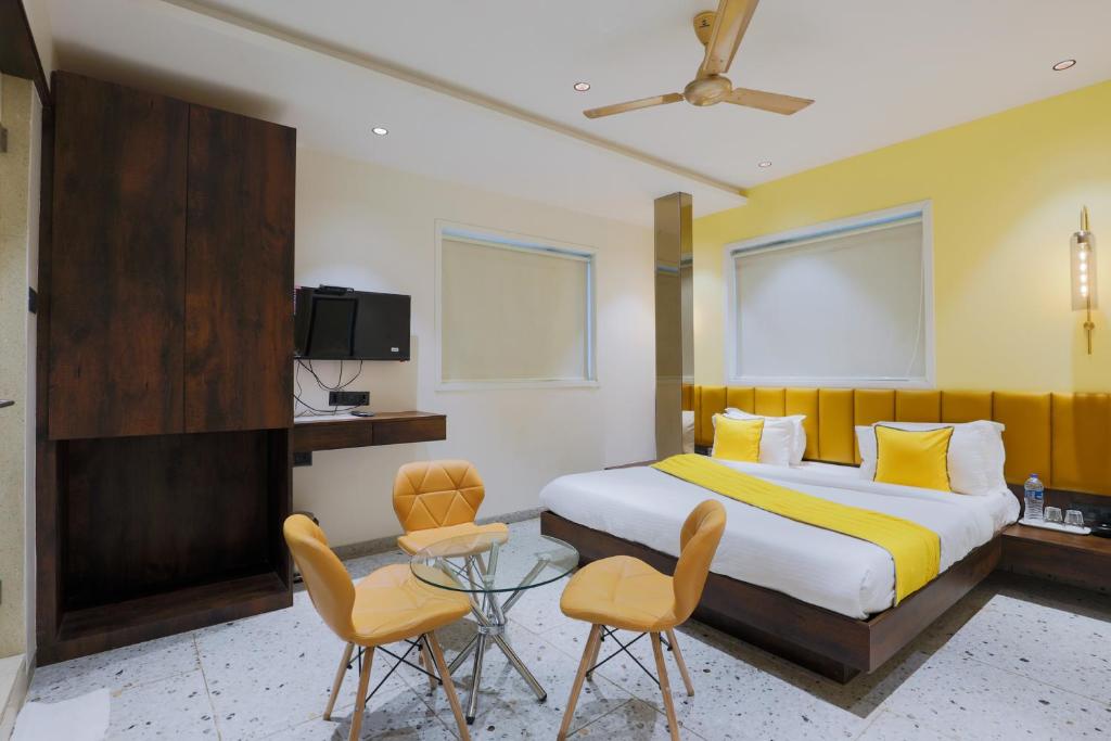 a bedroom with a bed and a table and chairs at The Cattleya Hotel - Near Marol, Andheri East, Mumbai in Mumbai