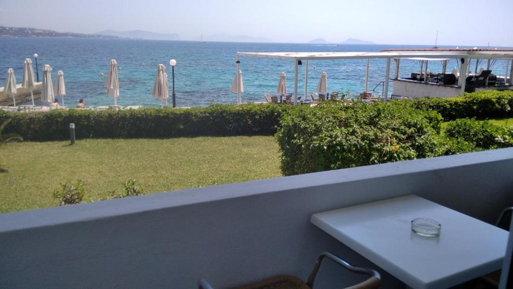 a white table on a balcony with a view of the ocean at Spetses Hotel in Spetses