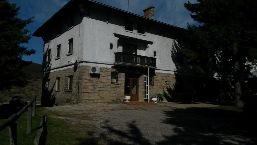 Casa de piedra antigua con balcón en el lateral en Хотел-ресторант Шипка,връх Шипка, en Prevala