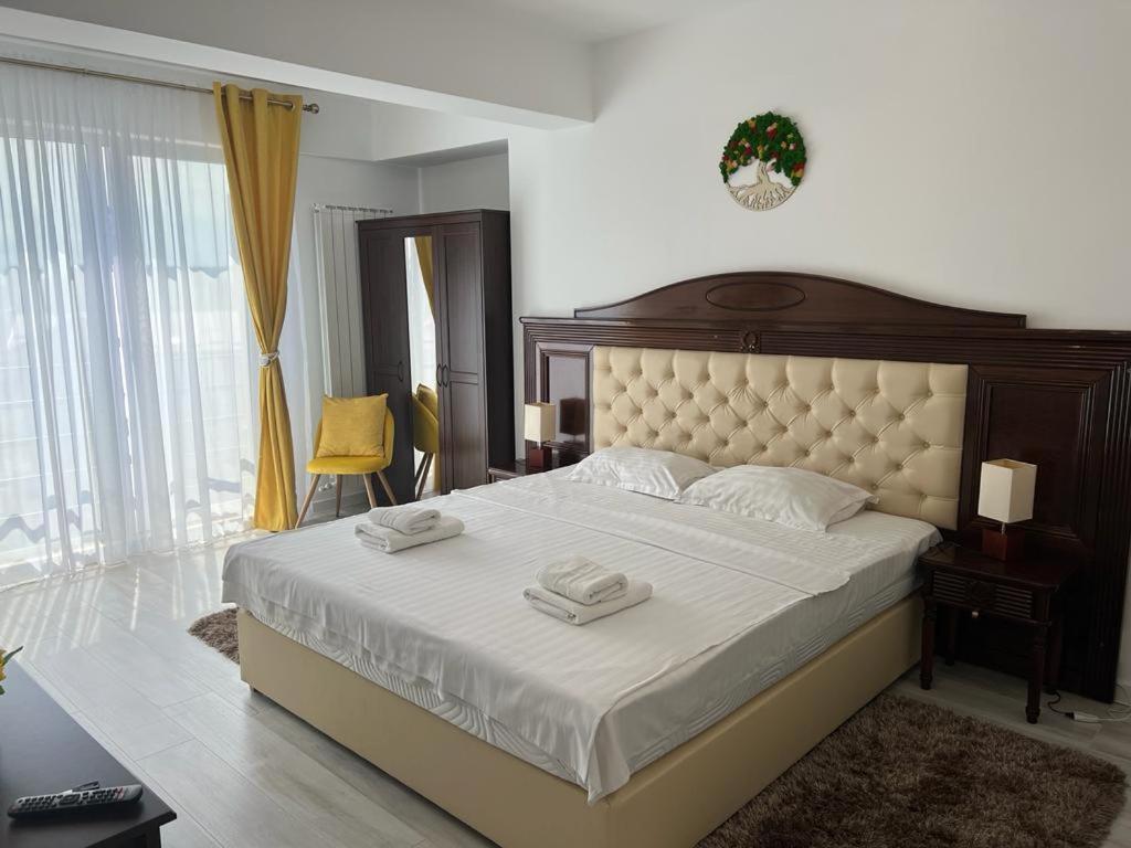 a bedroom with a large bed with two towels on it at Urban Accommodation - Palas Mall Iasi in Iaşi