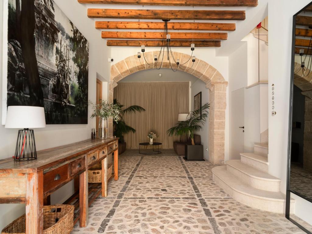a hallway with an archway and a table with a lamp at Can Verí Suites in Sóller