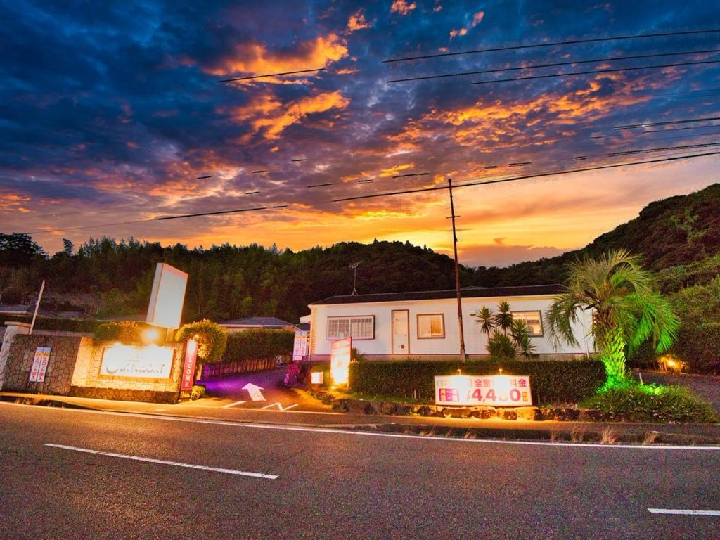 a house on the side of a street at sunset at SKY Ocean-terace Omura in Omura