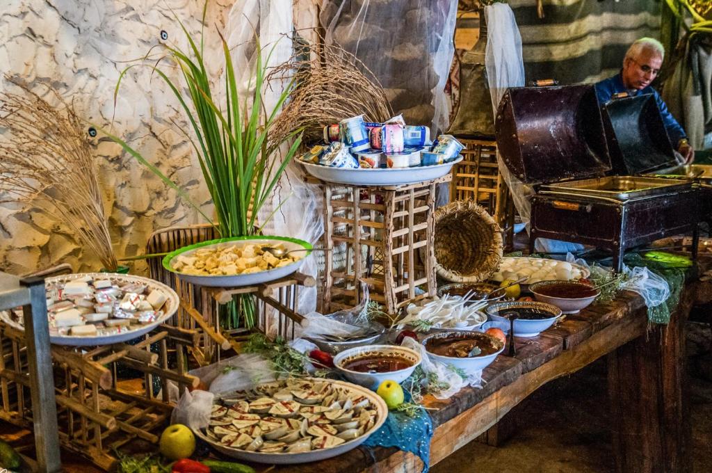 a table with many plates of food on it at Kfar Hanokdim - Desert Guest Rooms in Arad