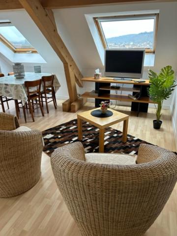 - un salon avec des chaises, une télévision et une table dans l'établissement Appartement - Stiring-Wendel, à Stiring-Wendel