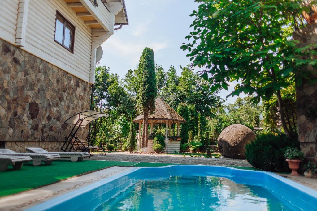 un patio trasero con piscina y cenador en Hotel Velyka Vedmedytsya, en Yaremche